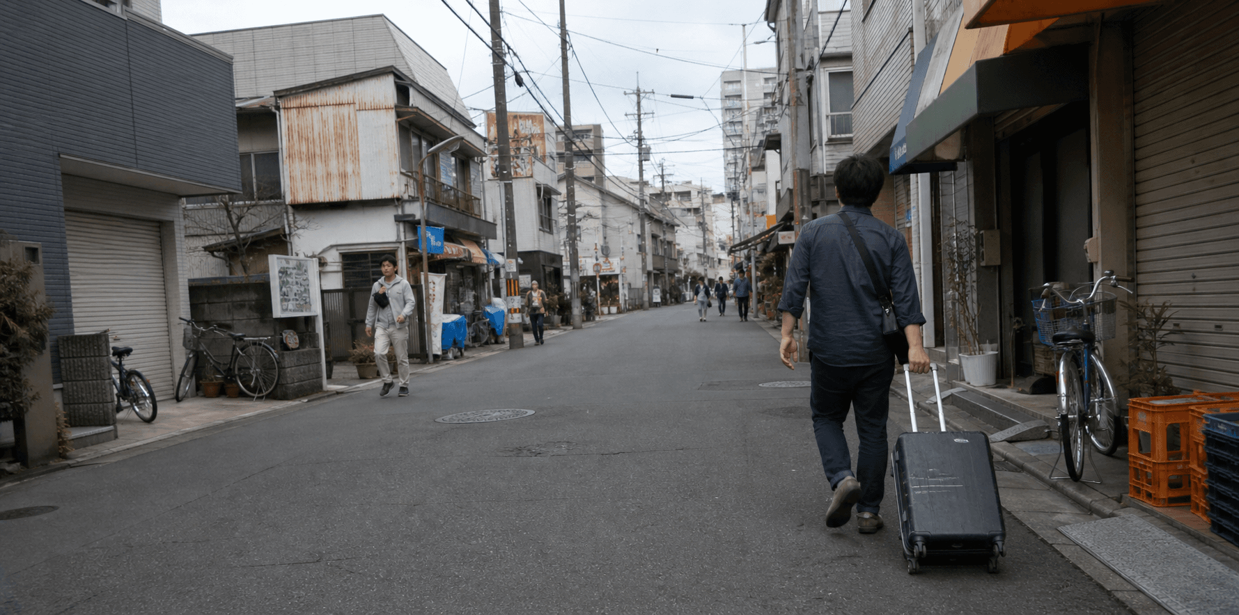 旅人拖著行李走在日本街道上